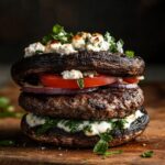 Low carb burger made with portobello mushroom buns, beef patty, and Mediterranean toppings