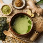 Ceramic Japanese Mounjaro Recipe bowl with whisked matcha, kombu in water, ginger, and umeboshi in a traditional Japanese kitchen-style setting